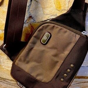 TUMI T-TECH Cross Body Shoulder Saddle Bag on a shade of green Y2K vintage